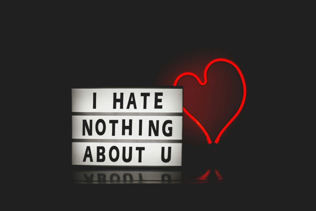 Simple image of a bright red neon heart and the words I Hate Nothing About U to go with the blog post about scrapbooking mom and her imperfections. Being honest while still honoring mom.